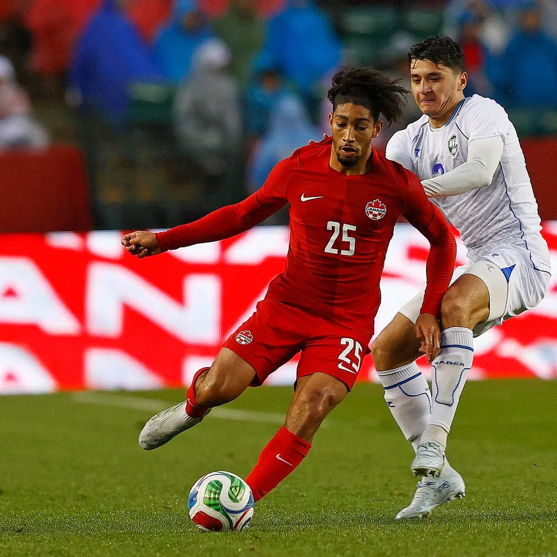 Jun 1, 2026; Edmonton, Ontario, CAN; Team Canada midfielder Nathan Saliba (25) makes a pass in front of Uzbekistan defender Abdukodir Khusanov (2) during the second half at Commonwealth Stadium. Mandatory Credit: Perry Nelson-Imagn Images