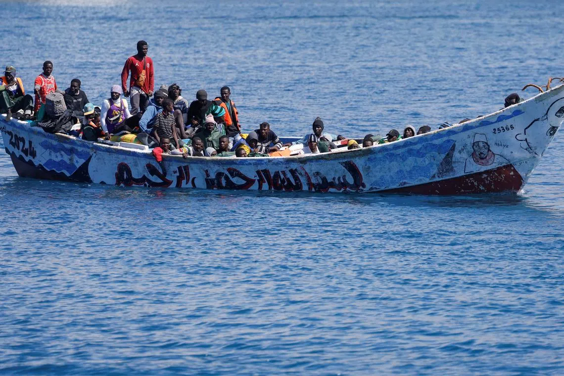 FILE PHOTO: Migrants wait to disembark from a fiber boat in the port of Arguineguin, on the island of Gran Canaria, Spain, March 28, 2024. REUTERS/Borja Suarez/File Photo