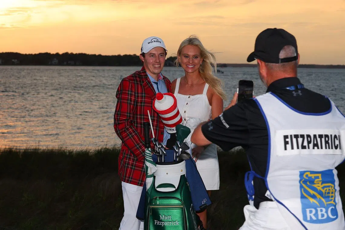 HILTON HEAD ISLAND, SOUTH CAROLINA - APRIL 16: Matt Fitzpatrick of England celebrates in the Heritage Plaid tartan jacket alongside girlfriend Katherine Gaal as caddie Billy Foster takes a photo after winning in a playoff during the final round of the RBC Heritage at Harbour Town Golf Links on April 16, 2023 in Hilton Head Island, South Carolina.   Kevin C. Cox/Getty Images/AFP (Photo by Kevin C. Cox / GETTY IMAGES NORTH AMERICA / Getty Images via AFP)