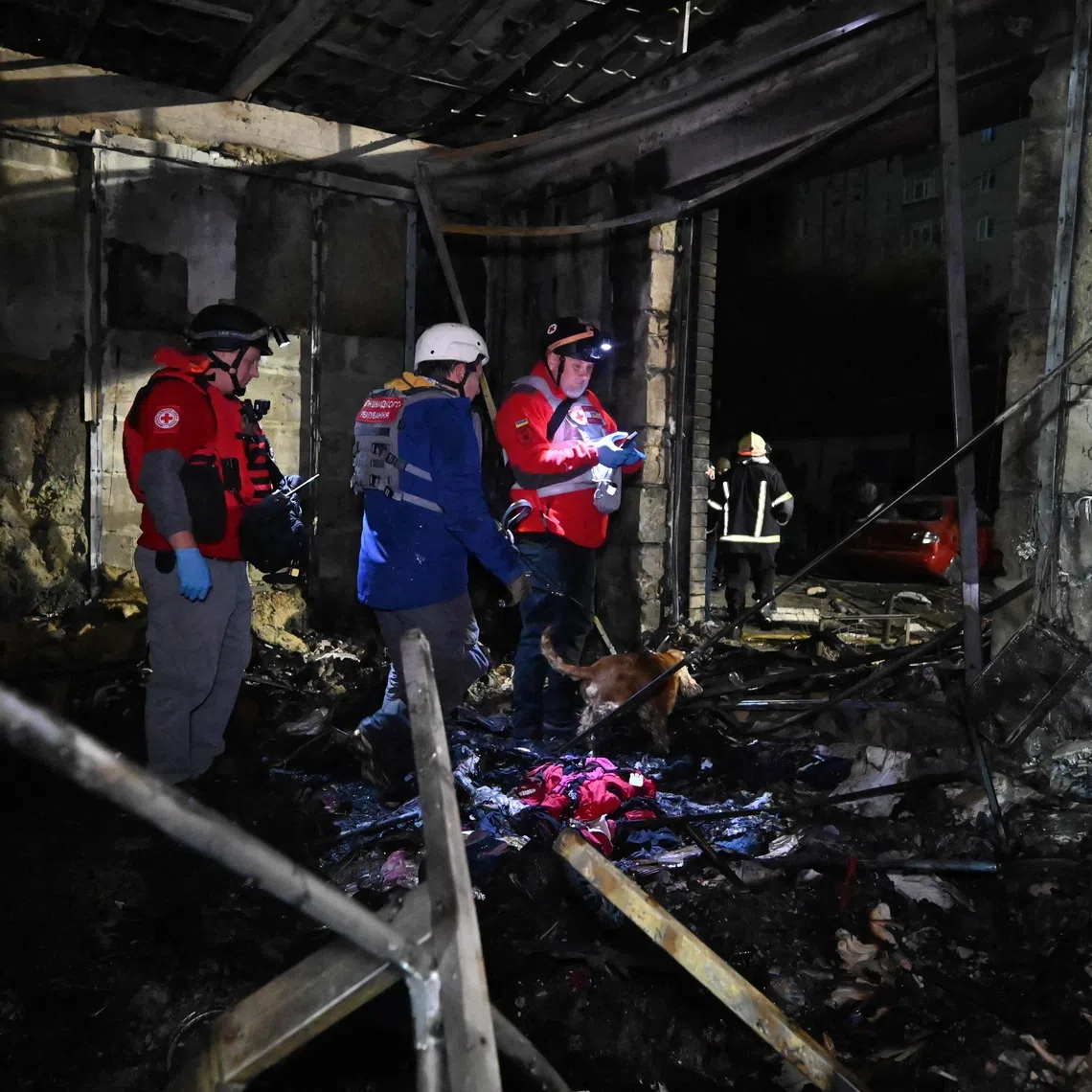 Rescuers work in a shop destroyed following a Russian missile attack on Oct 11 in Pesochin settlement, a suburb of Kharkiv, which killed three people and wounded 22.
