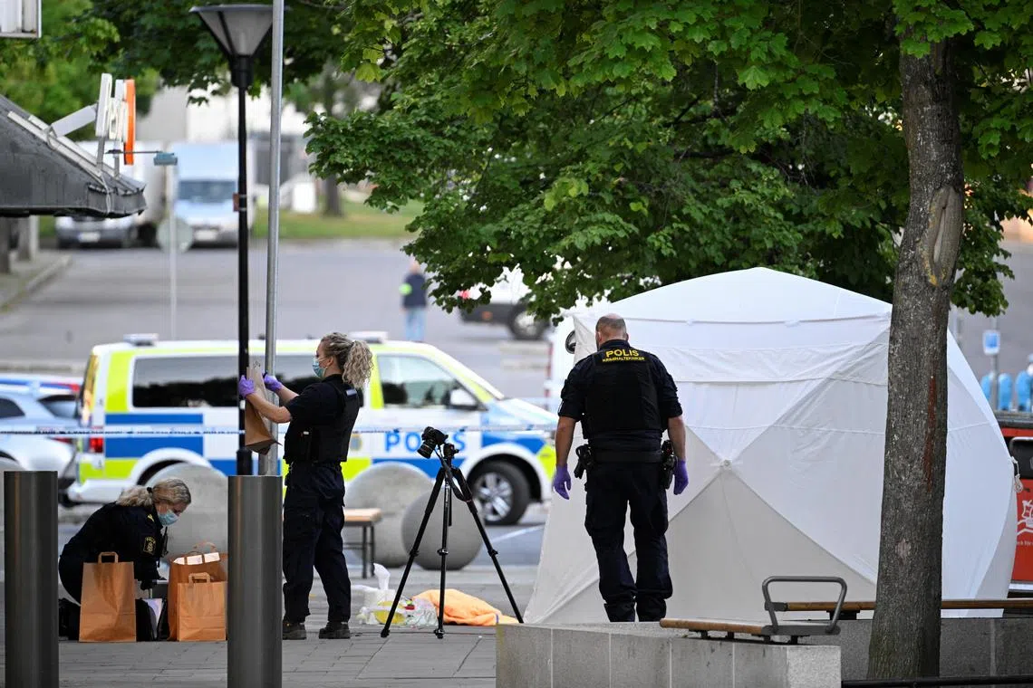 Police officers work at a site, following a shooting in Farsta, southern Stockholm, on Saturday. 