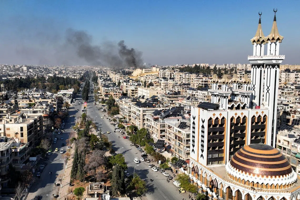 Smoke billows near residential buildings in a picture taken from a drone in Aleppo, Syria December 3, 2024. REUTERS/Mahmoud Hasano