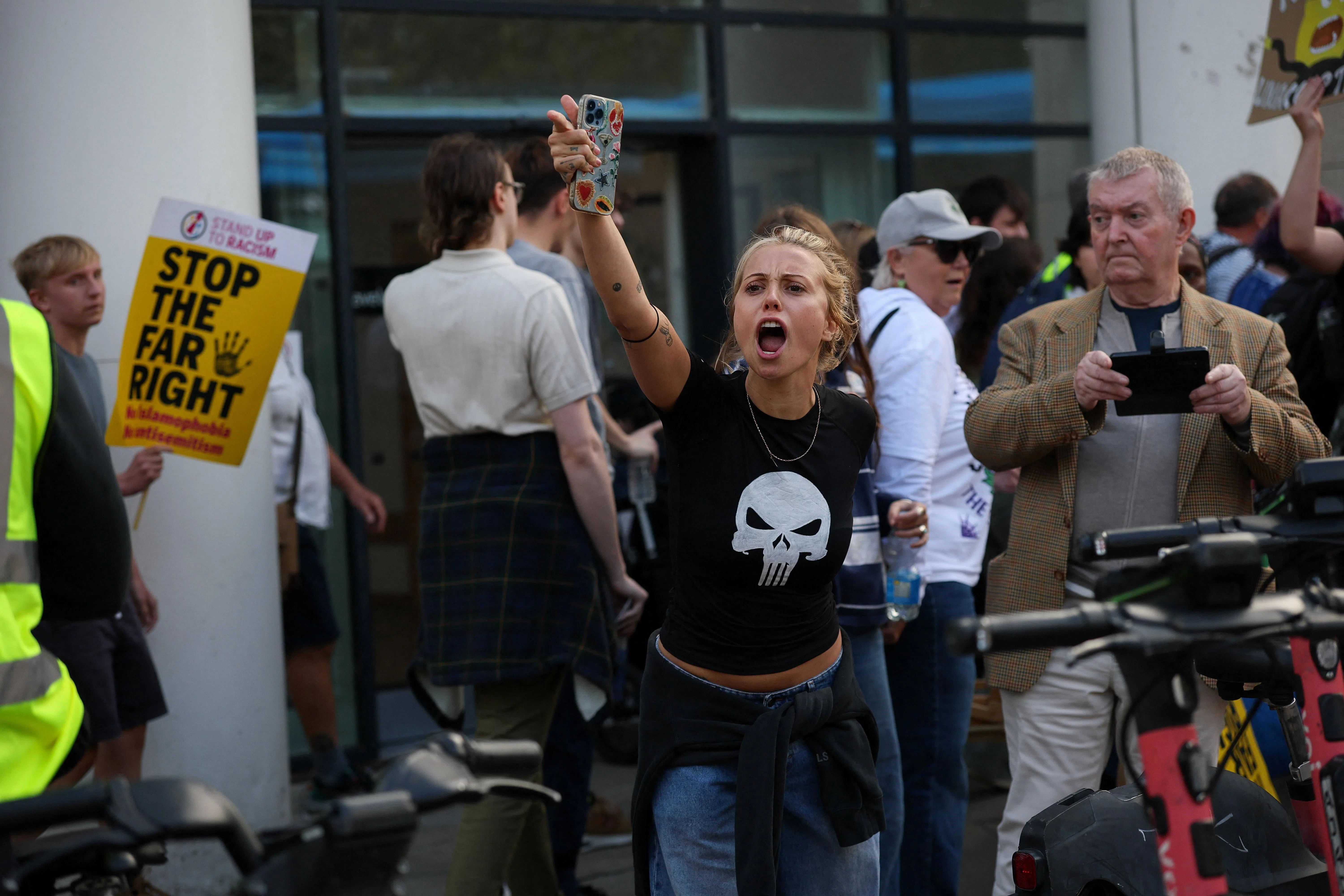 A woman taking part in the Stand Up To Racism counter-protest in Portsmouth gestures towards protesters from a group known as South Coast Patriots.