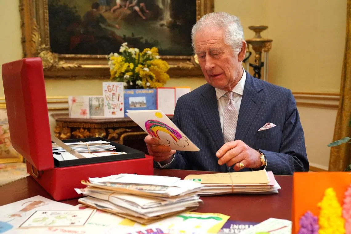 FILE PHOTO: Britain's King Charles reads cards and messages, sent by well-wishers following his cancer diagnosis, in the 18th Century Room of the Belgian Suite in Buckingham Palace, London, Britain, February 21, 2024. Jonathan Brady/Pool via REUTERS/File Photo