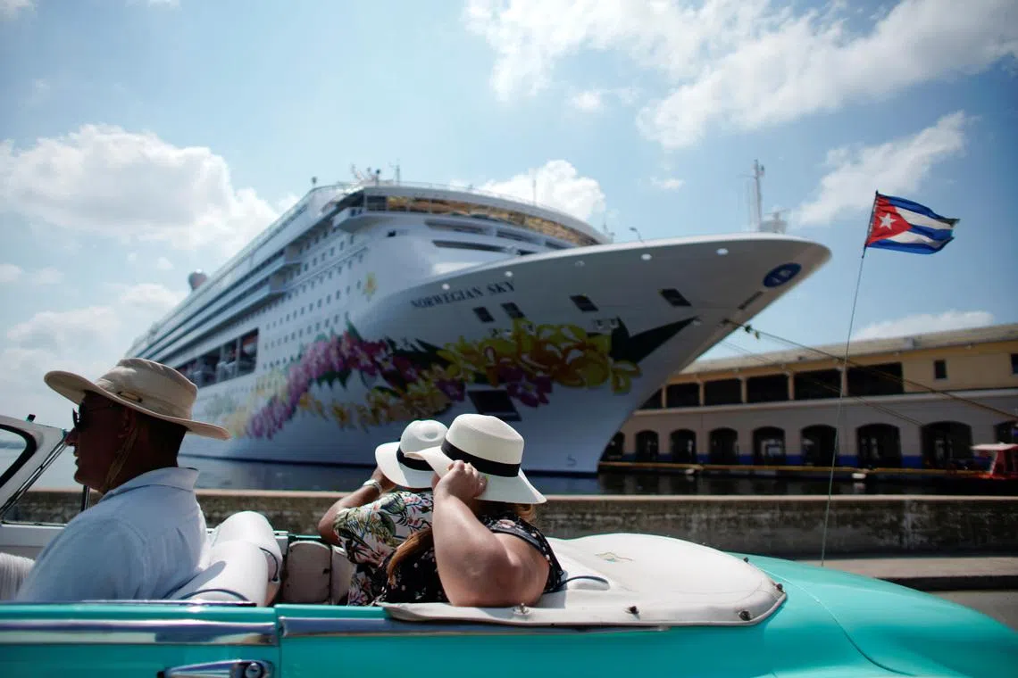 Tourists ride inside a vintage car as they pass by the Norwegian Sky cruise ship, operated by Norwegian Cruise Lines in Havana, Cuba, May 7, 2019. REUTERS/Alexandre Meneghini/File Photo