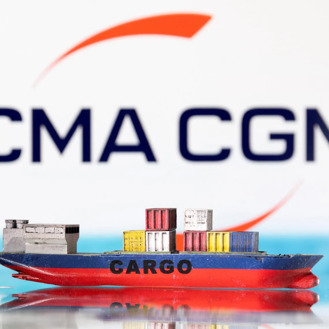 A cargo ship boat model is pictured in front of the CMA CGM logo in this illustration taken March 3, 2022. REUTERS/Dado Ruvic/Illustration