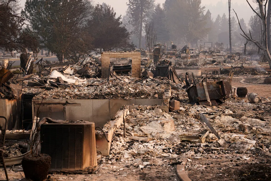 Extensive ruins and debris of a building surrounded by trees.