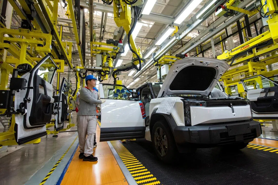 Employees work on the production line at a factory for Chery's electric vehicles (EV) in Wuhu, Anhui province, China July 29, 2024. China Daily via REUTERS  ATTENTION EDITORS - THIS IMAGE WAS PROVIDED BY A THIRD PARTY. CHINA OUT. 