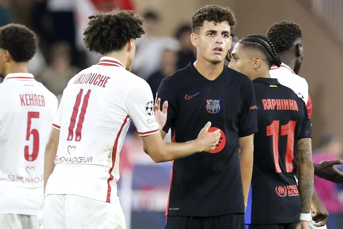 Maghnes Akliouche (left) of Monaco shakes hands with Barcelona's Sergi Dominguez after the match.