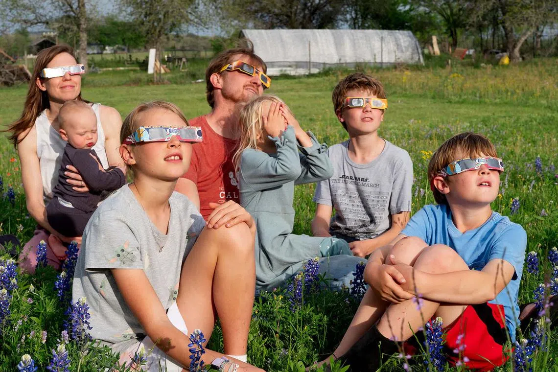 Jacob and Katie Rhodes watch the solar eclipse with their five children in Fredericksburg, Texas, April 8, 2024. 