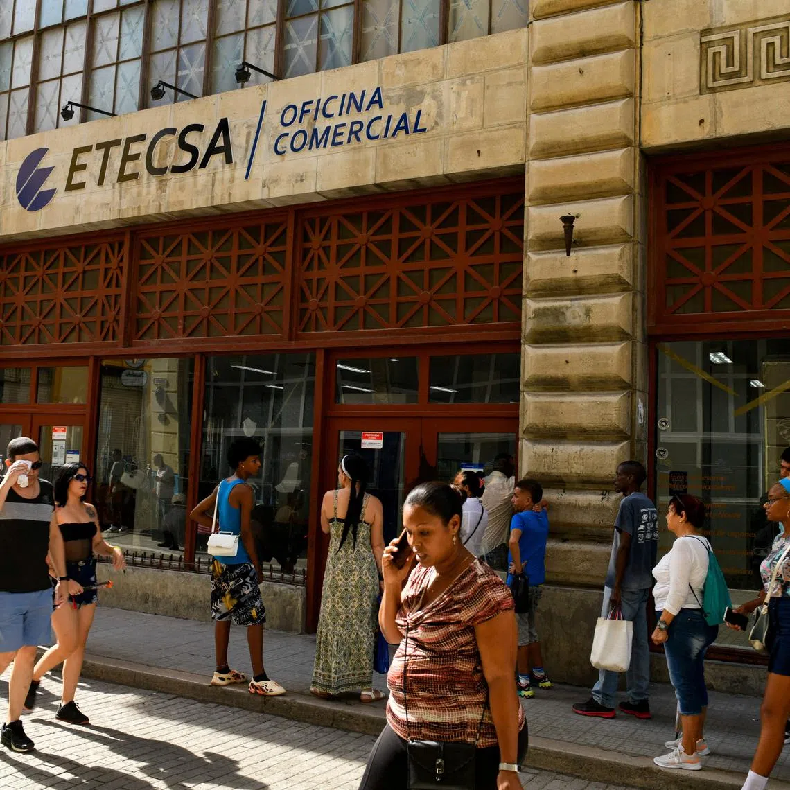 FILE PHOTO: People pass by an office of state-run telecommunications company ETECSA in Havana, Cuba June 3, 2025. REUTERS/Norlys Perez/File Photo
