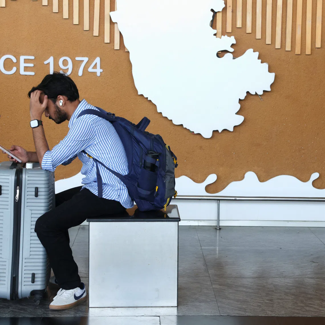 A traveller uses his mobile phone at Kempegowda International Airport in Bengaluru, India, December 6, 2025. REUTERS/Priyanshu Singh