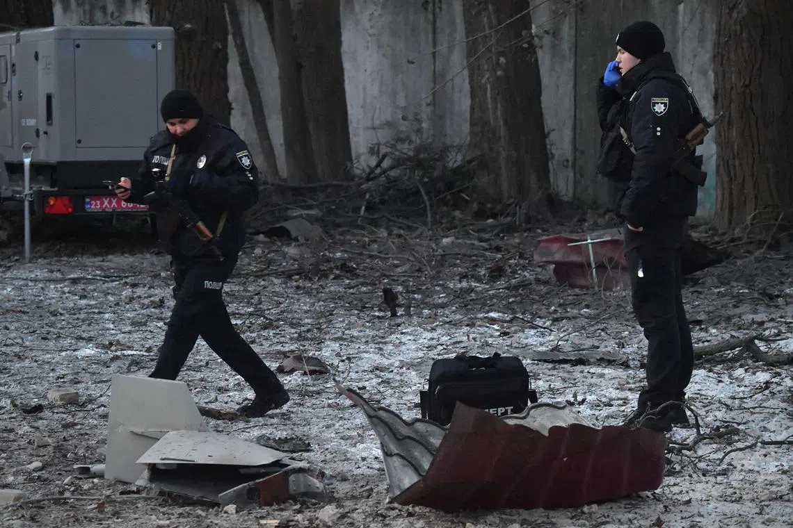 Rescuers and police experts examine the remains of a drone, following a strike on an administrative building in the Ukrainian capital Kyiv, on Dec 14, 2022.
