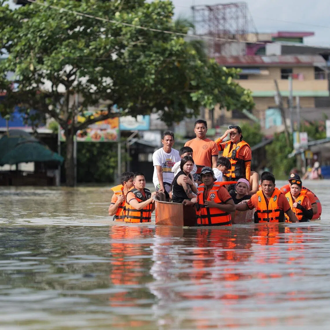 Rescuers pull an inflatable boat loaded with residents during a forced evacuation at a village in Tuguegarao City, Cagayan province, north of Manila on November 11, 2025, as flood waters continue to inundate homes due to heavy rains brought about by Super Typhoon Fung-wong. (Photo by John Dimain / AFP)