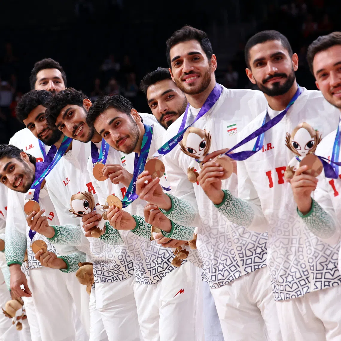 Iran’s team celebrate on the podium during the victory ceremony.