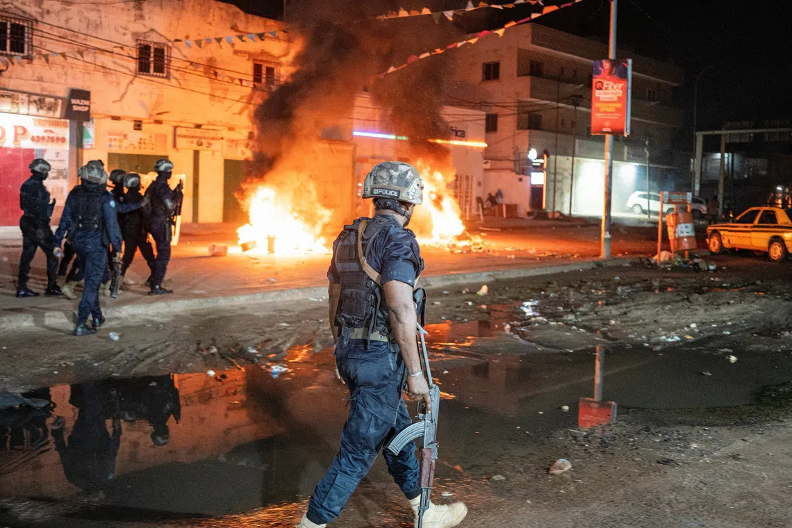 Police officers patrol near burning barricades as residents protest against power and water cuts in Banjul, Gambia, September 8, 2026. REUTERS/Malick Njie