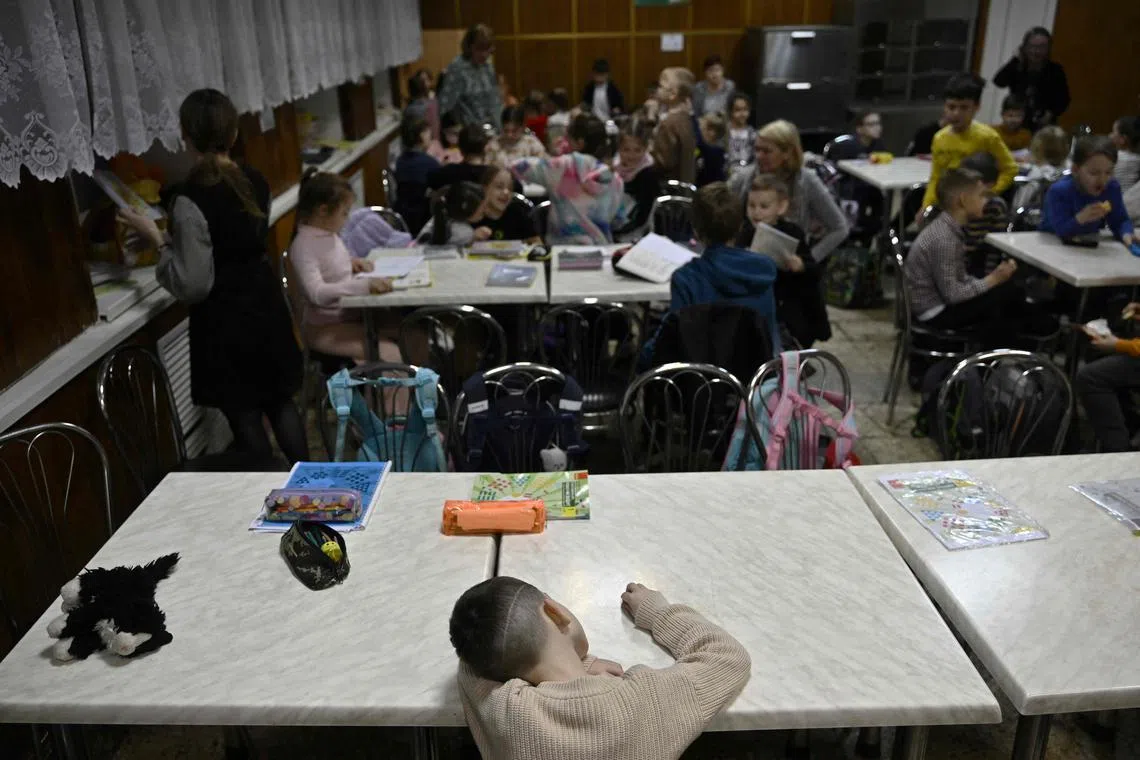 Children study in an air-raid shelter in the cellar of a school after an alarm signal in Kyiv on March 23.