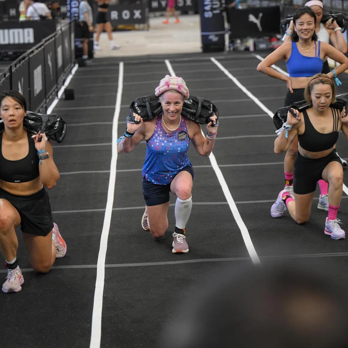 Carolyn Soemarjono (centre), a cancer survivor in her 60s, doing sandbag lunges during the Hyrox Singapore race held at the National Stadium on April 5, 2026.