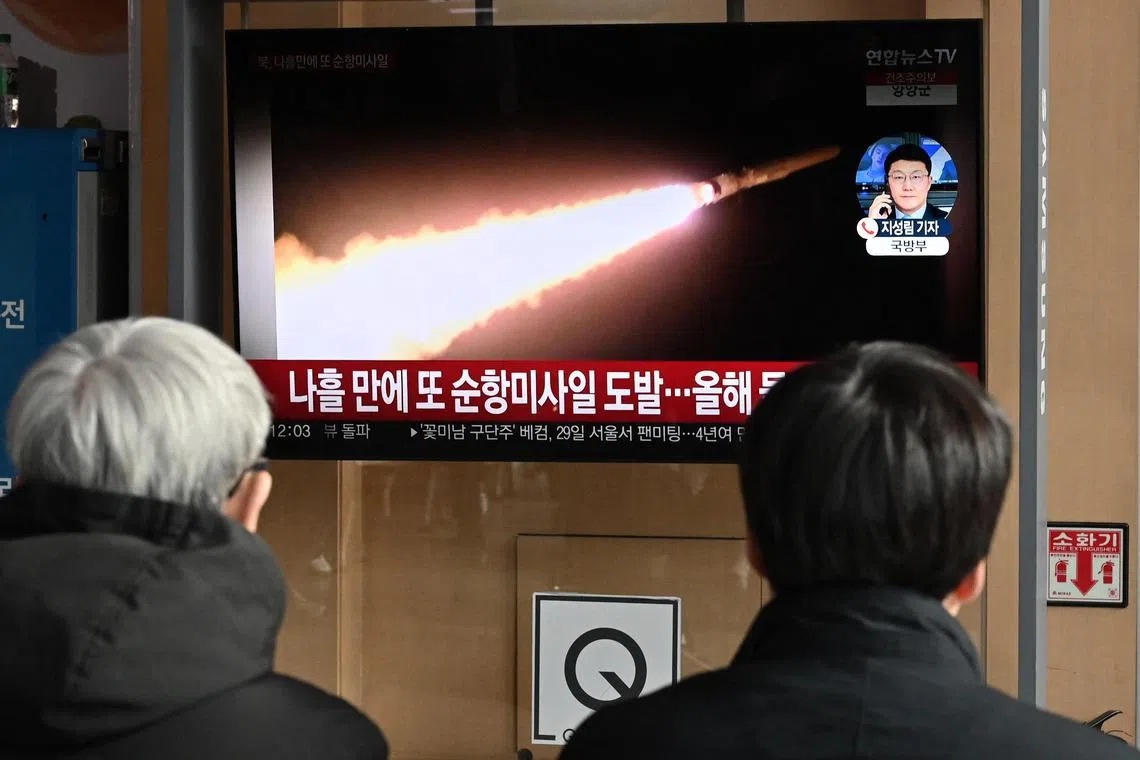 People watch a television screen showing a news broadcast with file footage of a North Korean missile test, at a railway station in Seoul on Jan 28.