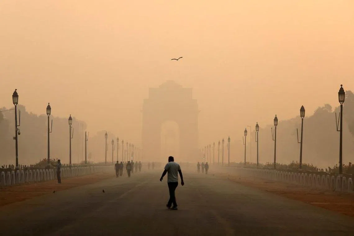 FILE PHOTO: A man walks in front of the India Gate shrouded in smog in New Delhi, India, October 29, 2018. REUTERS/Anushree Fadnavis/File Photo