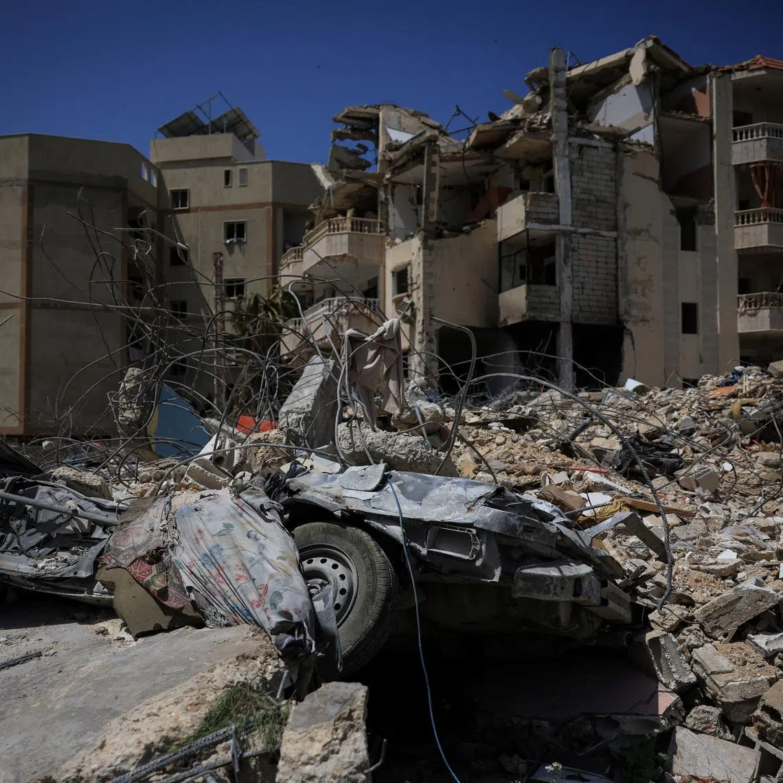 A damaged building, rubble and a destroyed vehicle in the aftermath of Israeli strikes, near Hiram Hospital in Tyre, south Lebanon, April 16, 2026. REUTERS/Louisa Gouliamaki