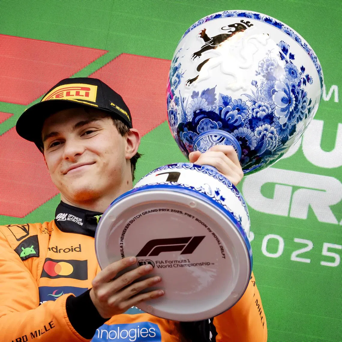 McLaren driver Oscar Piastri lifts his trophy after winning the Dutch Grand Prix at Zandvoort Circuit.