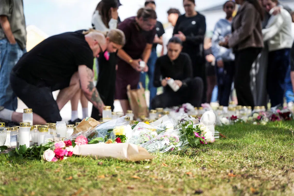 A makeshift memorial outside a school in Sweden where a man with a sword killed a 17-year-old girl.