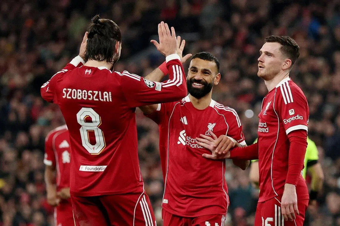Liverpool's Mohamed Salah celebrates scoring their third goal with teammates.