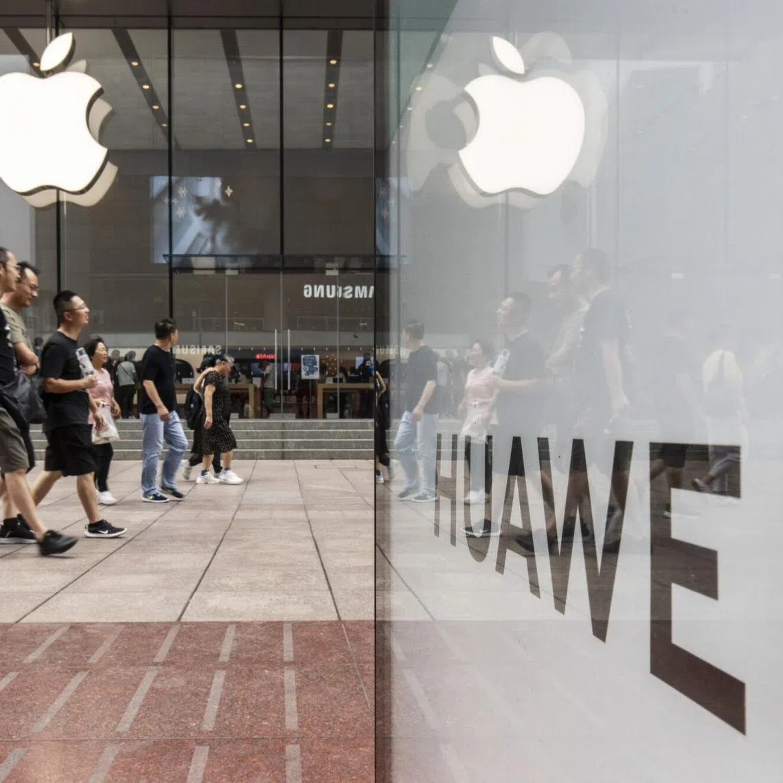 An advertisement for Huawei Technologies Co. across from an Apple Inc. store in Shanghai, China, on Tuesday, Sept. 10, 2024. Huawei announced the world's first commercial device with two folds, claiming leadership in mobile design just after Apple Inc. unveiled its latest iPhones. Photographer: Qilai Shen/Bloomberg