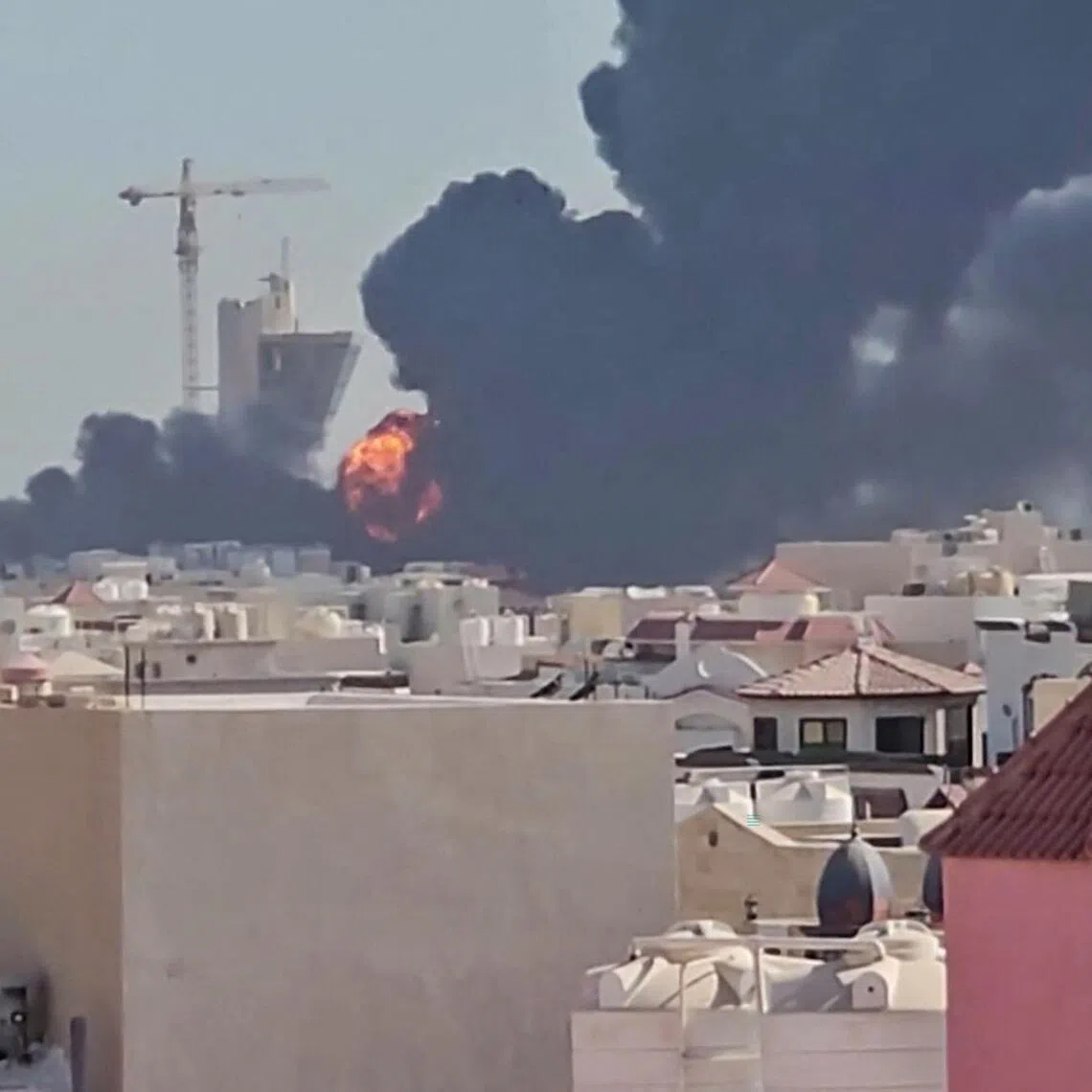 A plume of black smoke and flames billowing over the town of Mangaf, south of Kuwait City.