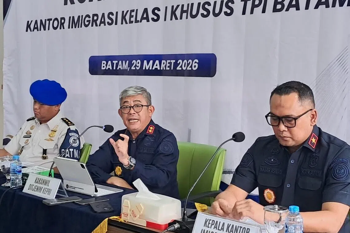 Immigration Directorate General Riau Islands Regional Office Head Ujo Sujoto (center) speaks while flanked by Batam Immigration Office Hajar Aswad (right) and an official from Internal Compliance Directorate Washington Napitupulu (left) on March 29, 2026, during a press conference at Batu Ampar Immigration checkpoint in Batam, Riau Islands. Ujo admitted there had been illegal levies and extortion practices at the Batam Center ferry terminal and promised severe punishment for those involved.