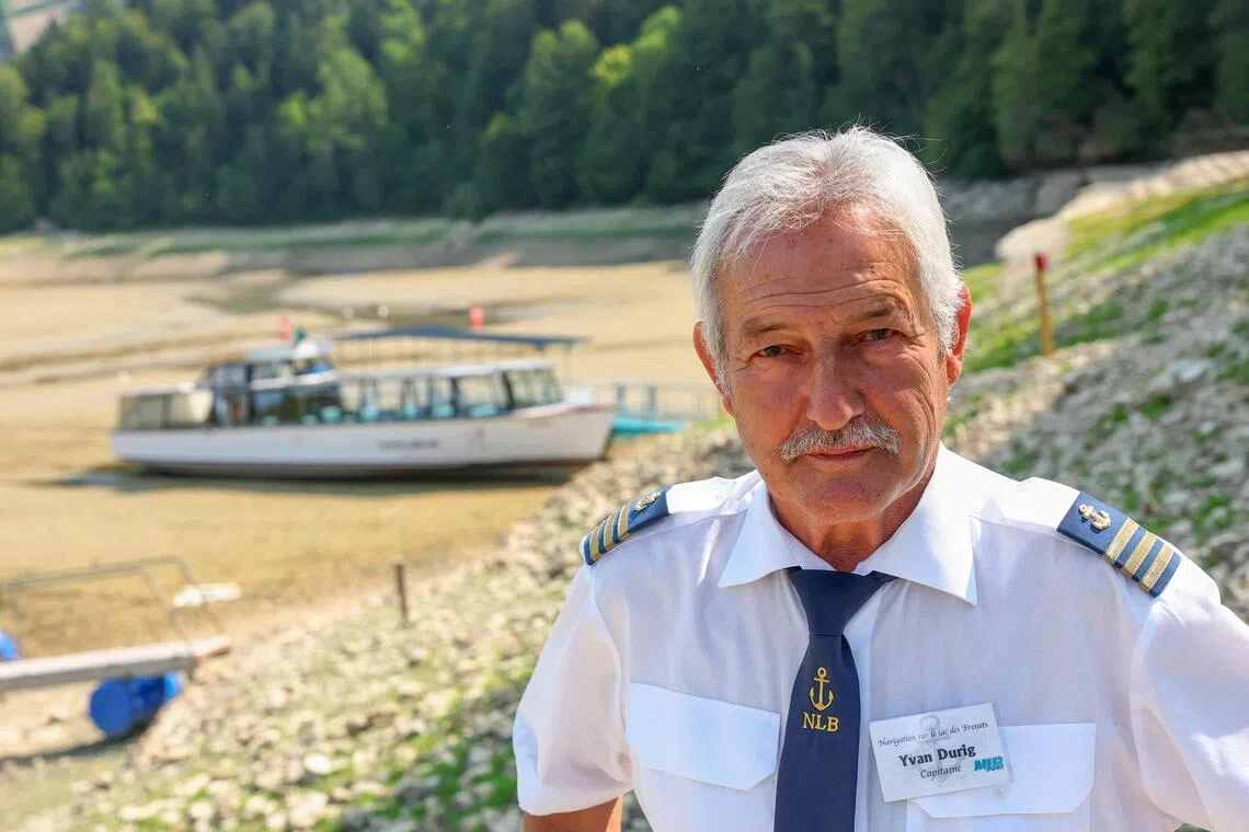 Yvan Durig, owner of the Societe de Navigation des Brenets, in front of a moored boat on the nearly empty Lake Brenet on July 30.