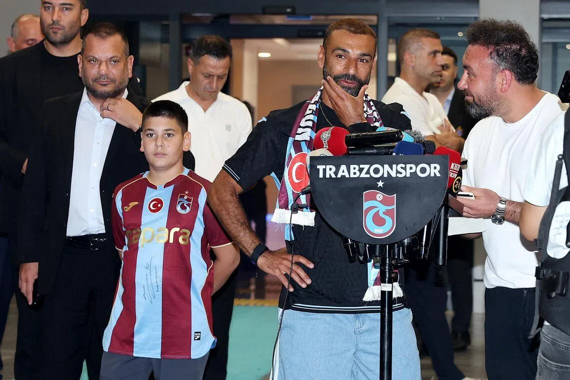Mohamed Salah is accompanied by Trabzonspor President Ertugrul Dogan as he arrives in the Black Sea city of Trabzon on Aug 5.