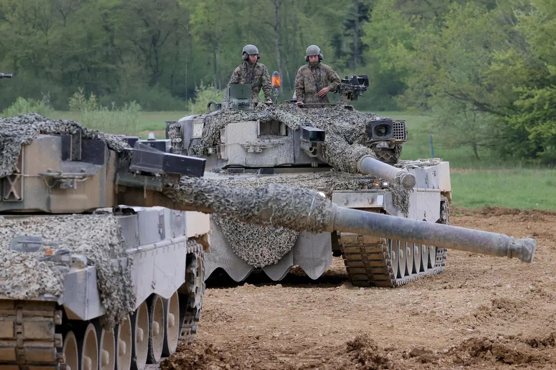Swiss army recruits perform an attack exercise aboard Leopard 2 tanks.