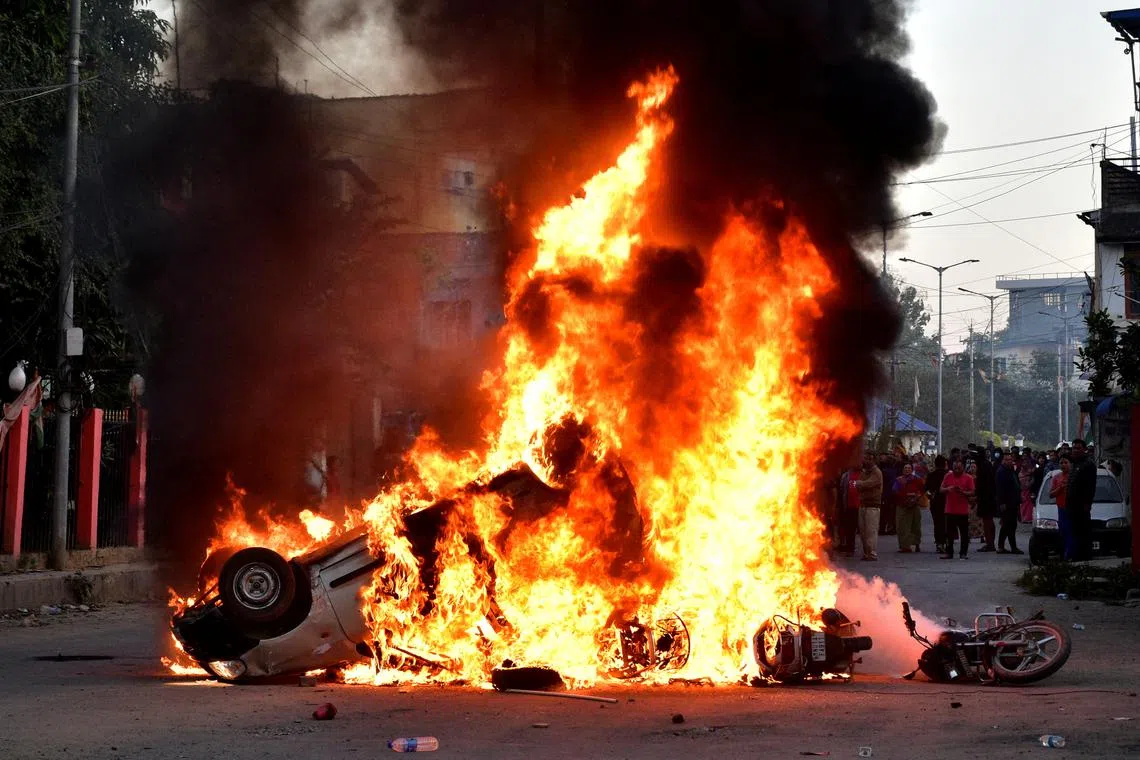Vehicles burn as demonstrators stand during a protest against the recent killings, in Imphal West, in the northeastern state of Manipur, India, November 16, 2024. REUTERS/Stringer