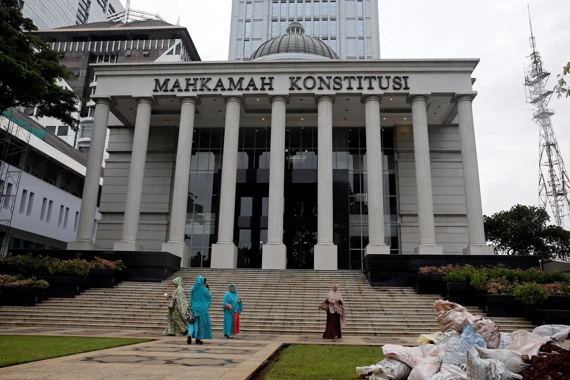 FILE PHOTO: Muslim women walk in front of Indonesia's constitutional court in Jakarta, Indonesia, December 14, 2017. REUTERS/Beawiharta/File Photo