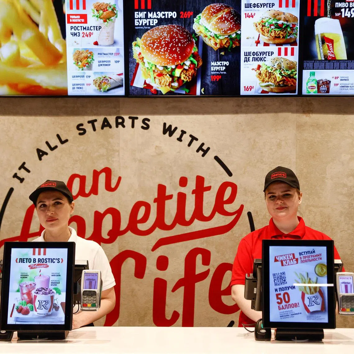 Employees stand at a cashier desk in a former KFC restaurant, which re-opens under the brand Rostic's after American firm Yum!Brands Inc sold its fast food chain KFC in Russia to a local operator, in Moscow, Russia, April 25, 2023. REUTERS/Maxim Shemetov