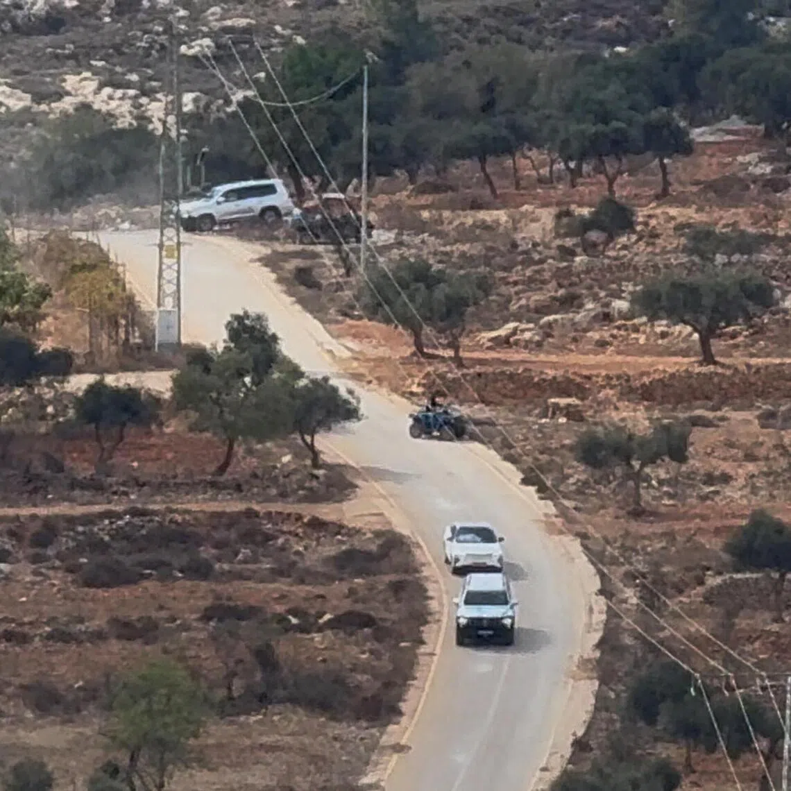 Vehicles drive at the site where Belgium’s foreign minister says masked settlers in the Israeli-occupied West Bank attacked Palestinians, Catholic representatives and Western diplomats and officials.