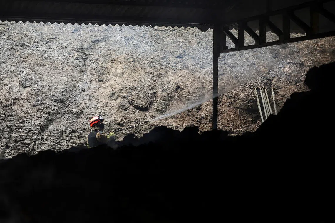 A firefighter working at a partially burnt down cattle farm after a wildfire devastated the area, in Uiseong, South Korea, on March 27, 2025.