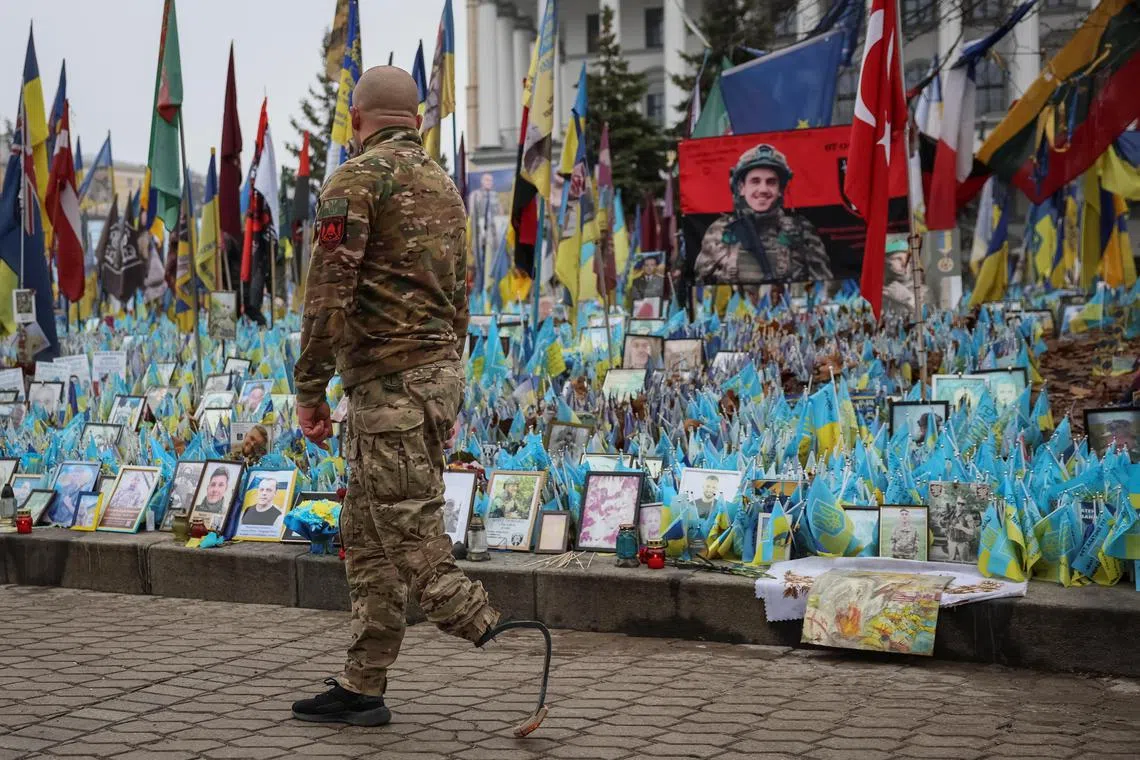 A Ukrainian serviceman visiting a memorial to fallen soldiers at Kyiv's Independence Square, in December 2024.