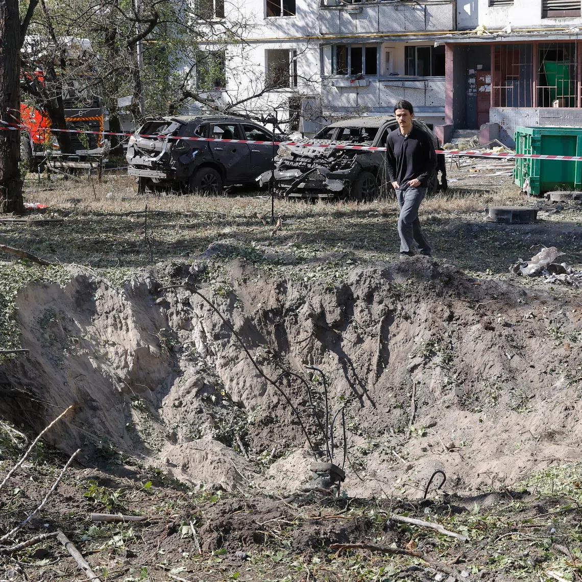 A man looks at a missile crater at the site of a Russian strike on a high-rise residential building in Kyiv, Ukraine.