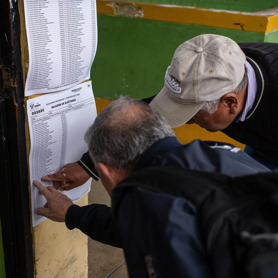 epa13280980 Two men are looking for their polling station on a list for the regional and municipal elections in Lima, Peru, 04 October 2026. More than 26.3 million voters are called to the polls to elect a total of 13,148 regional and municipal authorities.  EPA/Paolo Aguilar