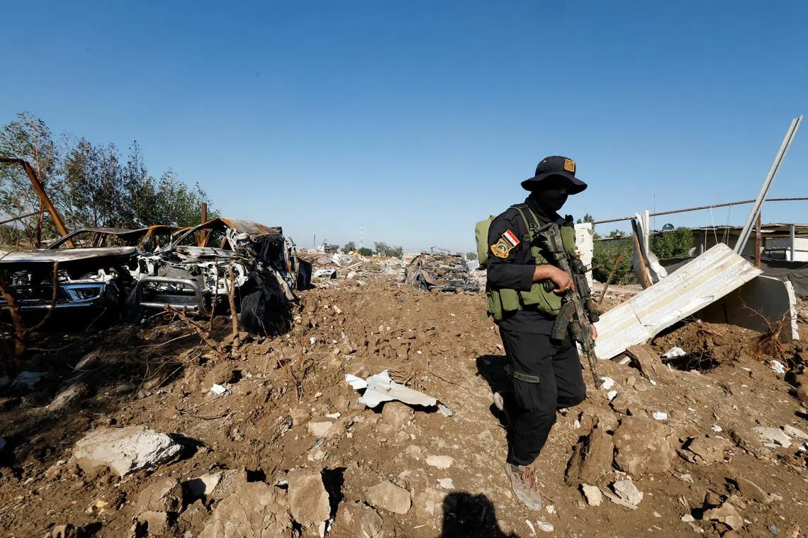 FILE PHOTO: A fighter of the Iraqi Kataib Hezbollah militia group inspects the site of a U.S. airstrike, in Hilla, Iraq December 26, 2023. REUTERS/Alaa al-Marjani/File Photo