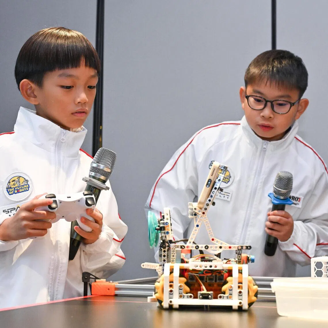 ST20251118-202545600901-Lim Yaohui-Sarah Koh-sarobot/
RoboBuddies team consisting of Chua Ming Feng Skylar, (right) 11, primary five student from Nanyang Primary School, and Elon Chan, 9, primary three student from New Town Primary School, giving a demonstration of their robot, during media preview at New Bahru on Nov 18, 2025.
The World Robot Olympiad (WRO), one of the world's leading global robotics championships, will be hosting its 2025 International Finals in Singapore from 26-28 November 2025. As the birthplace of WRO, which first began in Singapore in 2004, the championship’s return marks a full-circle moment for the global robotics community. The WRO International Finals will bring together over 500 teams and 3,000 participants from around the world, supported by dedicated local volunteers and international judges.
(ST PHOTO: LIM YAOHUI)