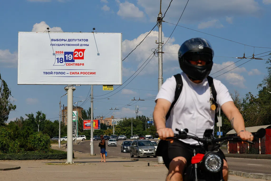 A cyclist passes a billboard announcing Russia's parliamentary election scheduled for September, during the Russia-Ukraine conflict in Donetsk, a Russian-controlled city of Ukraine, August 7, 2026. REUTERS/Alexander Ermochenko