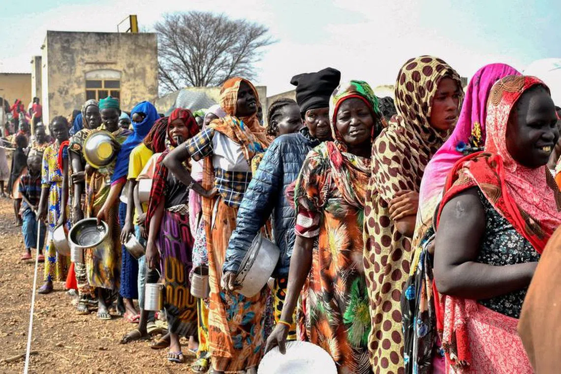 Women who fled the war-torn Sudan following the outbreak of fighting between the Sudanese army and the paramilitary Rapid Support Forces (RSF) queue to receive food rations at the United Nations High Commissioner for Refugees (UNHCR) transit centre in Renk, near the border crossing point in Renk County of Upper Nile State, South Sudan May 1, 2023. REUTERS/Jok Solomun/File Photo