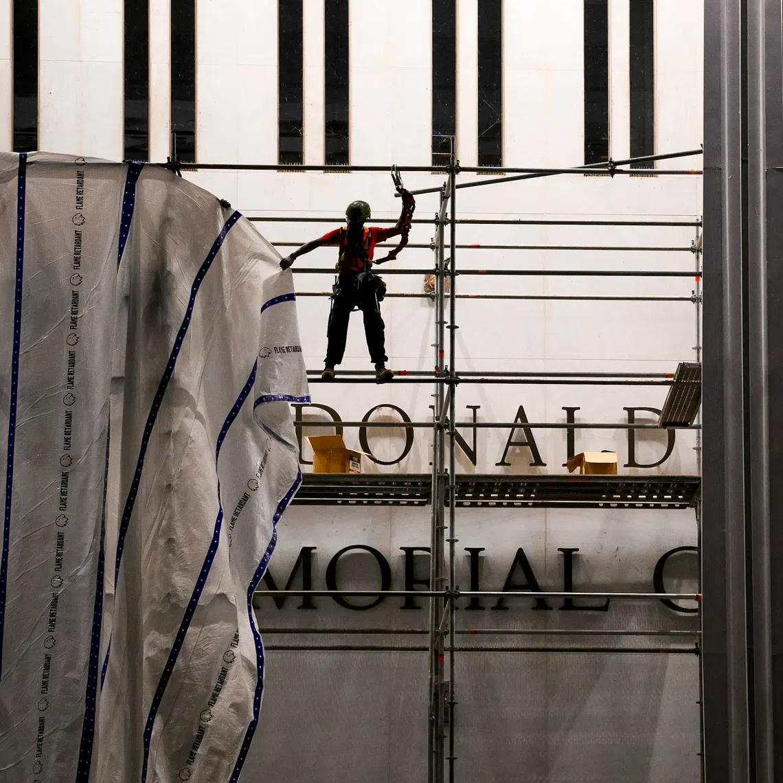 A tarp is attached to scaffolding as workers prepare to remove President Donald Trump’s name from the facade of the John F. Kennedy Center for the Performing Arts in Washington, on June 12, 2026.