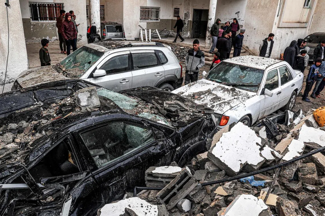 People inspect the wreckage of cars destroyed during an Israeli bombardment in the southern Gaza city of Rafah.