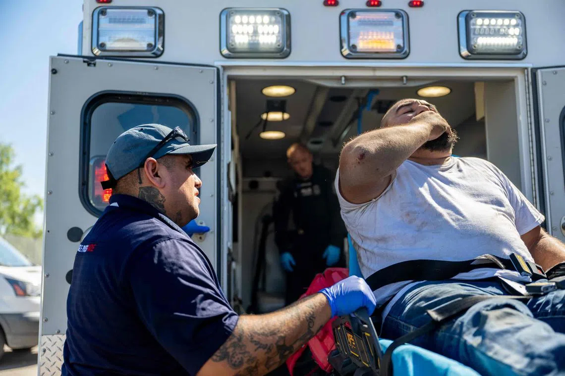 Medical responders help a patient who called in with chest pain after working outside for hours during a heatwave, in Eagle Pass, Texas.