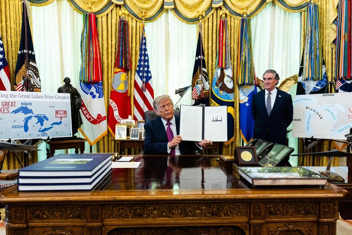 US President Donald Trump holding up an executive order he signed on Aug 27, to change the name of Lake Ontario to Lake America.